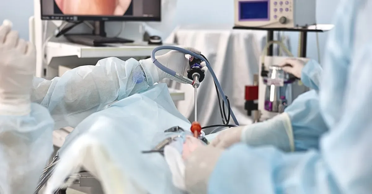 Surgical team performing arthroscopic meniscus repair with the joint displayed on a monitor.